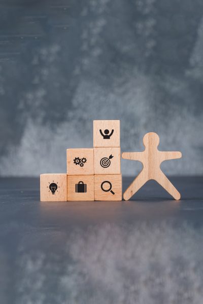 Conceptual of success and target. with wooden human and blocks on dark color background side view. horizontal image